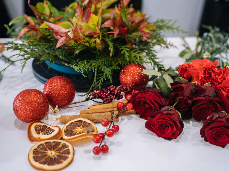A collection of festive decorations to be used in a Christmas wreath making class.